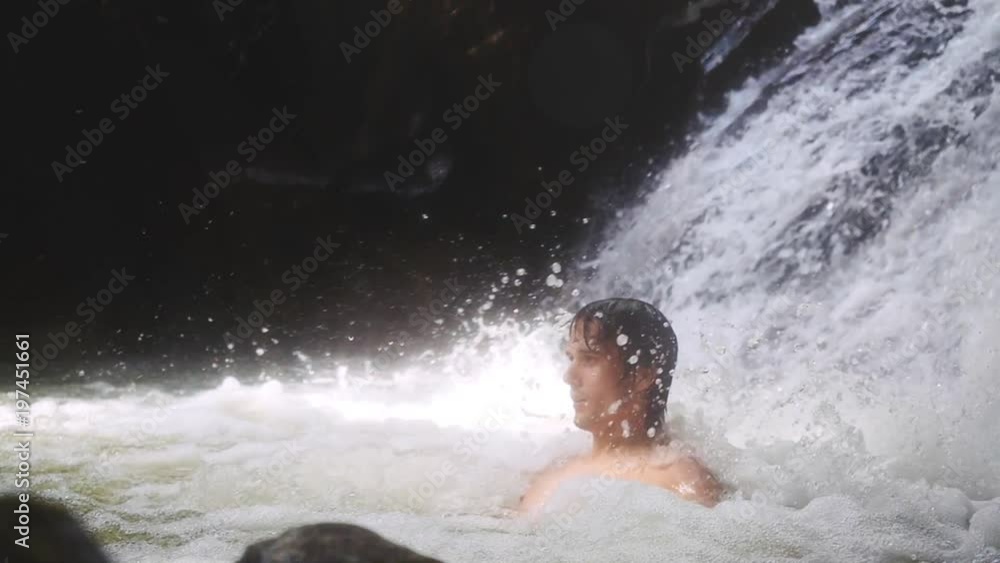 Handsome sexy man relaxing under stream water in waterfall in tropical jungle. slow motion. 1920x1080 Handsome sexy man relaxing under stream water in waterfall in tropical jungle. slow motion. 1920x1080