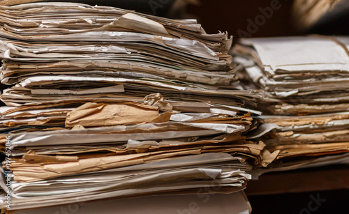 Old dusty stack of papers, files, documents on the shelves of archive room