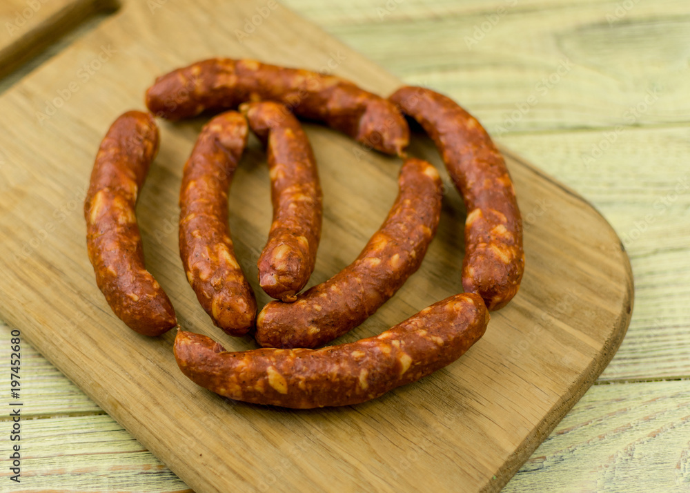 Smoked natural sausages on a wooden surface. Smoked natural sausages on a wooden surface.