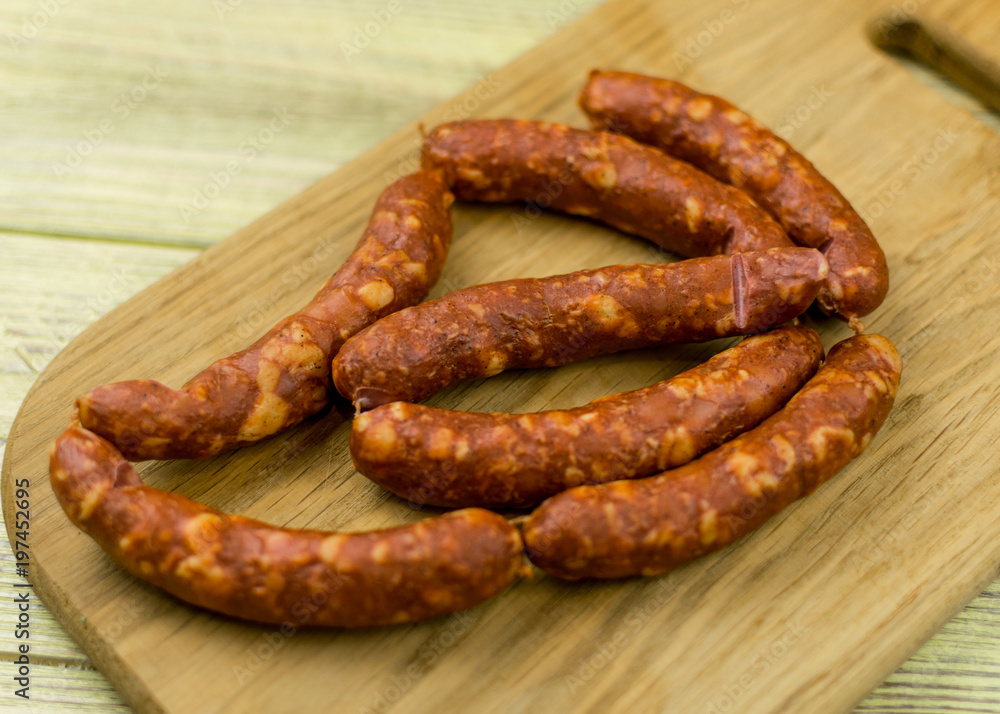Smoked natural sausages on a wooden surface. Smoked natural sausages on a wooden surface.