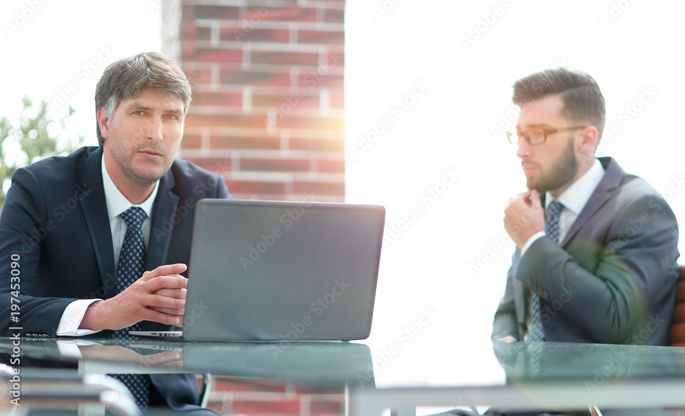 Two businessmen working on a laptop in the office Two businessmen working on a laptop in the office