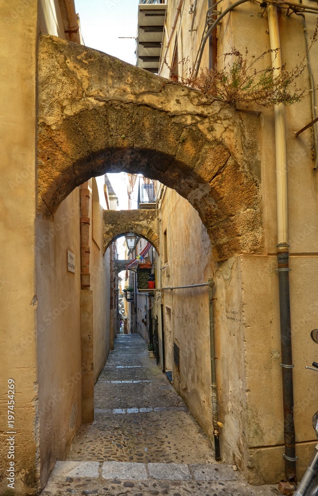 Cefalù, Italy, Sicily August 16 2015. The alleys of cefalù that wind at the foot of the fortress behind the cathedral. Steep stairways, picturesque signs. Narrow streets, flower boxes, laundry threads