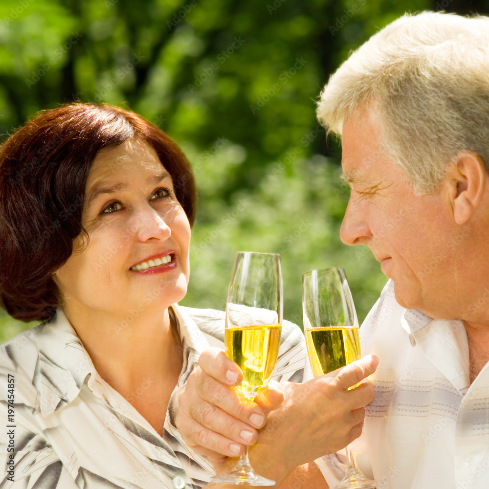 Senior couple celebrating with champagne, outdoors Senior couple celebrating with champagne, outdoors