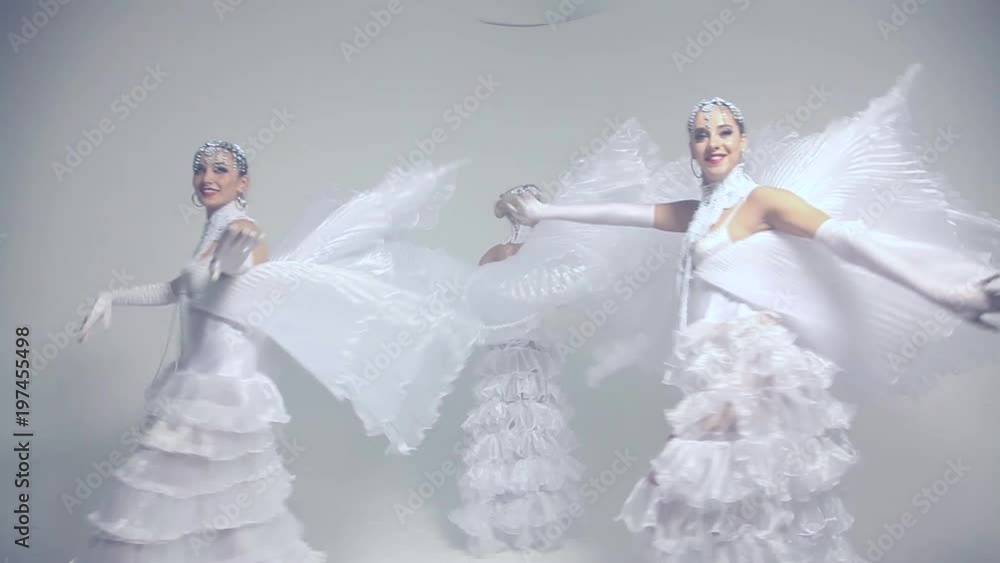 Thee young beautiful women dancing in white costumes Thee young beautiful women dancing in white costumes