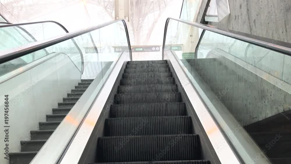 The escalator moves upstairs to a railway station that is covered in fog. The Central Lisbon railway station at the early morning in a fog. The escalator moves upstairs to a railway station that is covered in fog. The Central Lisbon railway station at the early morning in a fog.