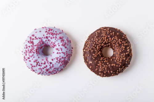Glazed berry and chocolate donuts with sweet sprinkles on white background