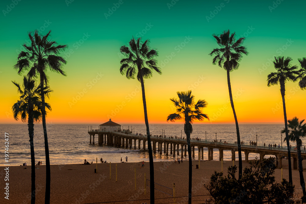Naklejka premium Manhattan plaża z drzewkami palmowymi i molem przy zmierzchem w Los Angeles, Kalifornia. Przetwarzane w stylu vintage. Moda podróży i koncepcja tropikalnej plaży.