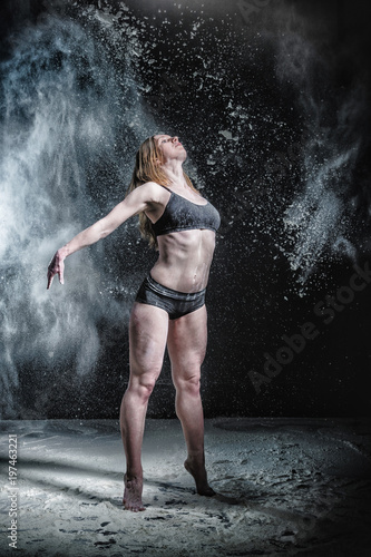 Girl dansing with flour on black background