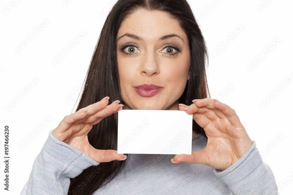 Smiling woman showing empty blank paper card sign with copy space for text Smiling woman showing empty blank paper card sign with copy space for text