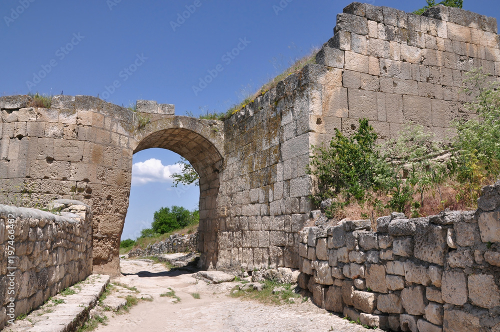 Street of the ancient city. Stone wall and arch of old ruins.