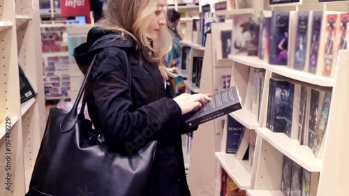 Young woman looking book in bookstore
