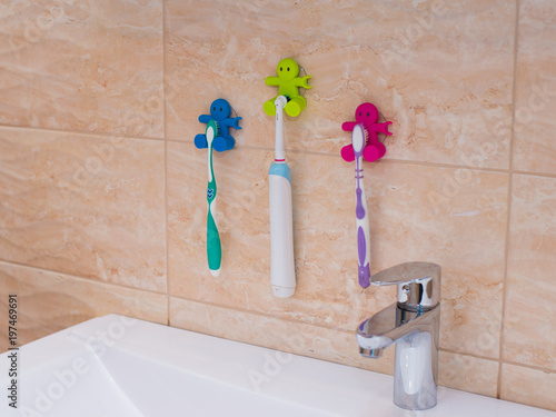 White bath accessories: bar of soap in soap-dish, liquid soap, toothbrushes