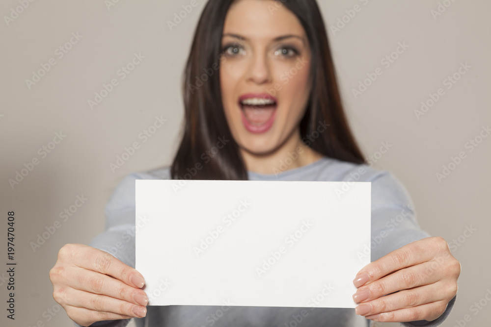 Happy woman showing empty blank paper card sign with copy space for text Happy woman showing empty blank paper card sign with copy space for text