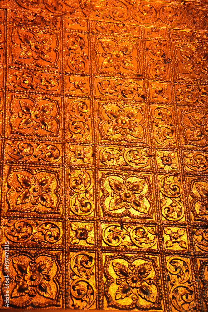 Close up of a golden wall designed with flowers inside the Buddhist Botataung pagoda, Yangon, Myanmar.
