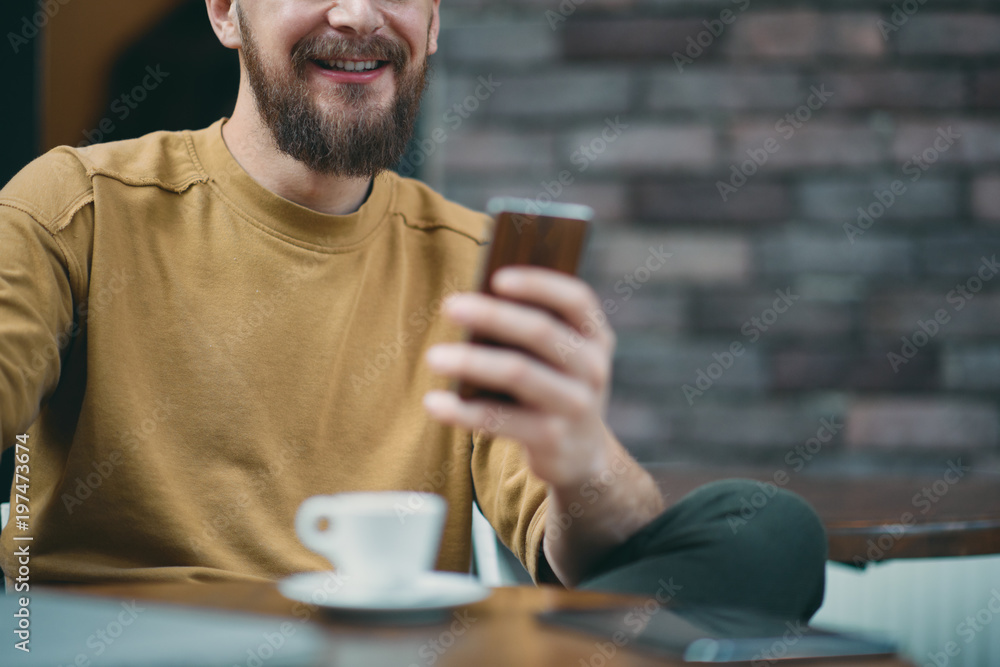 Young man sitting in cafe and using smart phone. Young man sitting in cafe and using smart phone.
