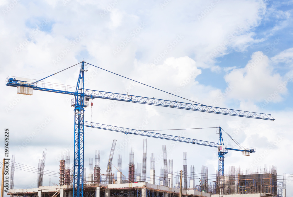 big blue cranes in building construction site on blue sky background