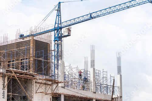 big blue cranes in building construction site on blue sky background