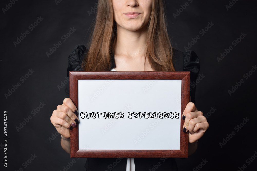 In the hands of a businessman a frame with the inscription:CUSTOMER EXPERIENCE In the hands of a businessman a frame with the inscription:CUSTOMER EXPERIENCE