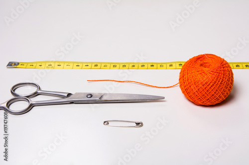 Background for tailor orange thread, measuring tape and scissors photo