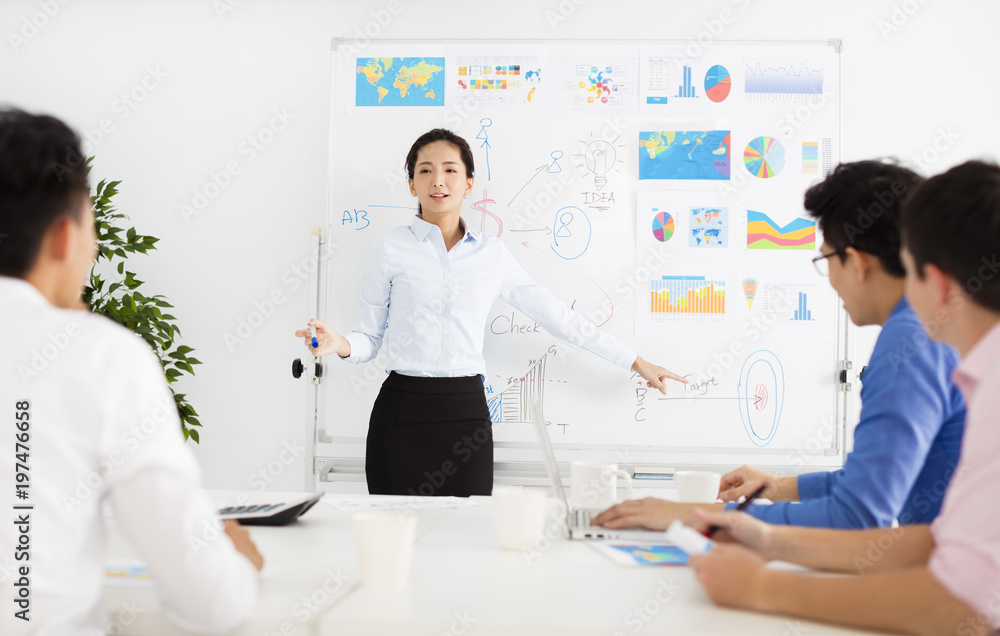 young Businesswoman presenting to colleagues at meeting. young Businesswoman presenting to colleagues at meeting.