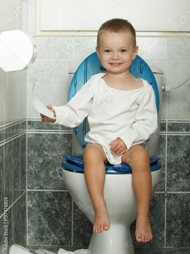 little baby sitting on the toiltet