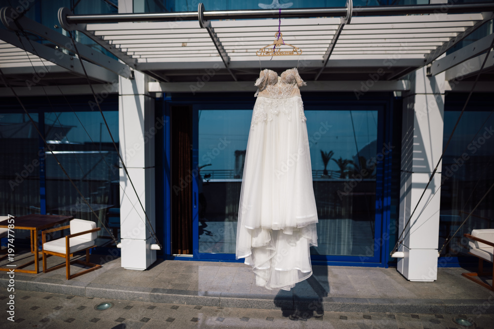 wedding dress hanging on a hanger near the hotel wedding dress hanging on a hanger near the hotel
