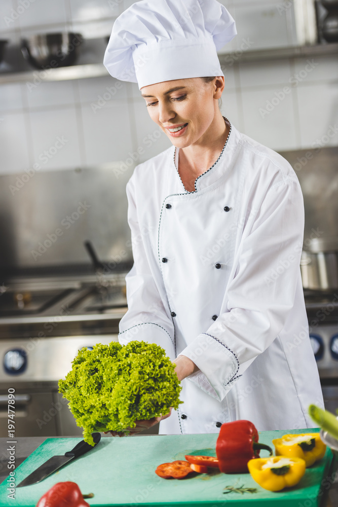 attractive chef holding lettuce leaves at restaurant kitchen attractive chef holding lettuce leaves at restaurant kitchen
