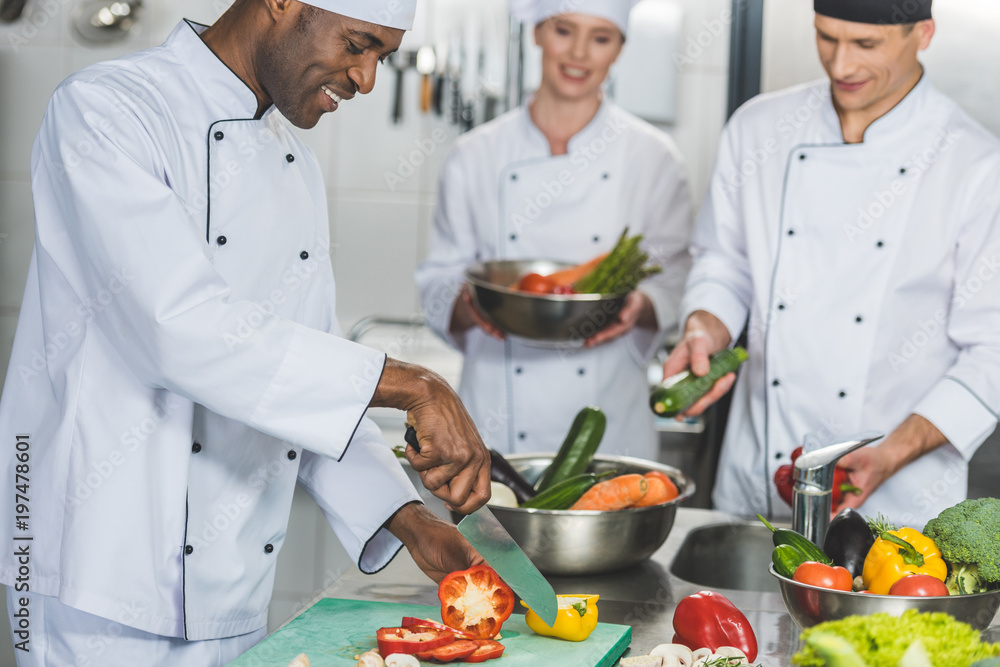 multicultural chefs cooking salad at restaurant kitchen multicultural chefs cooking salad at restaurant kitchen