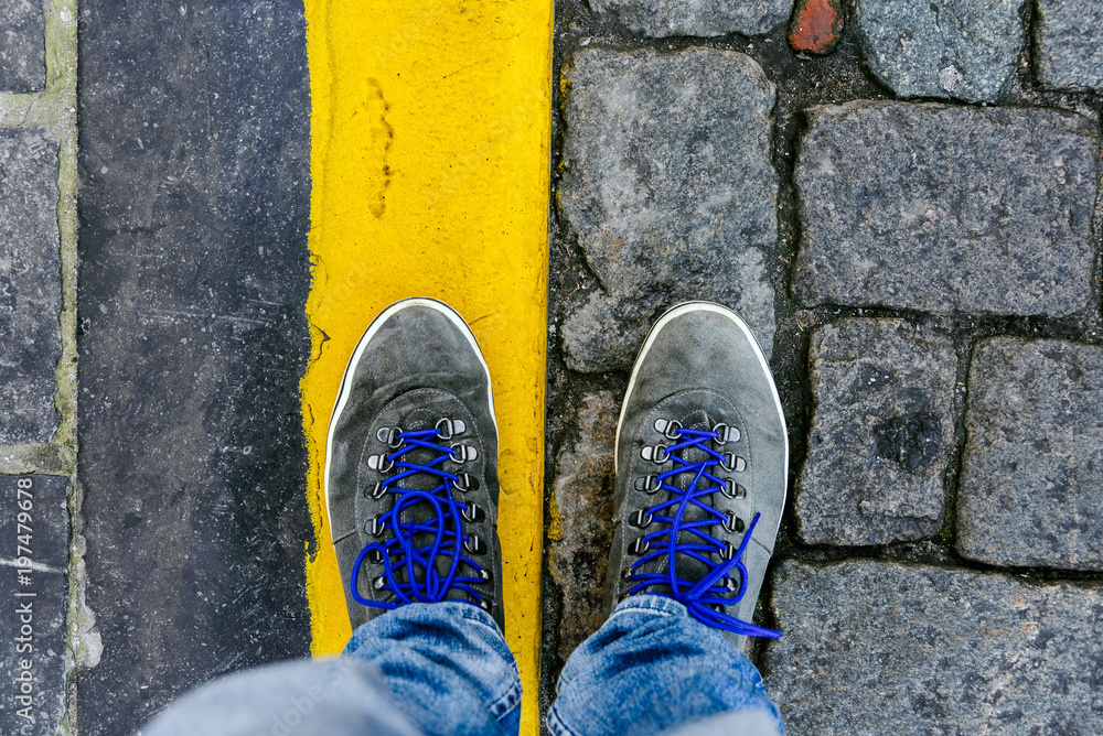 Concept of facing a crucial decision shown by shoes on different colored pathways