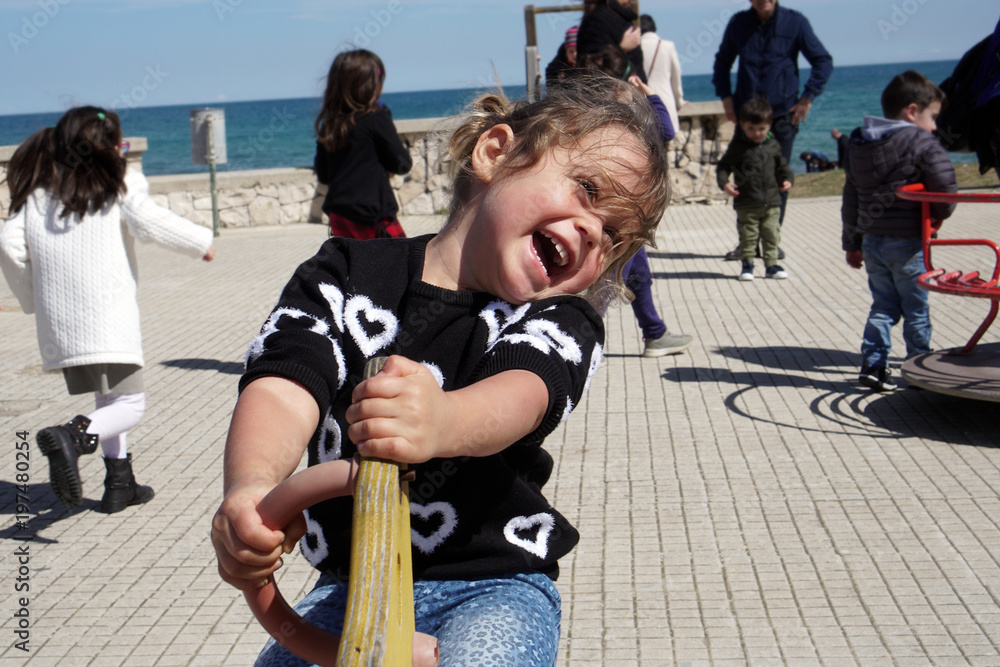 Fototapeta premium Little girl plays happy in a playground