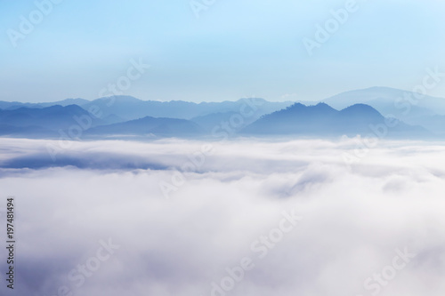 landscape view of sunrise on high angle view with white fog in early morning over rainforest mountain in thailand  © Soonthorn