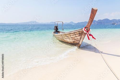 Longtail boat mooring on the tropical beach in the andaman sea krabi Thailand on sunny day