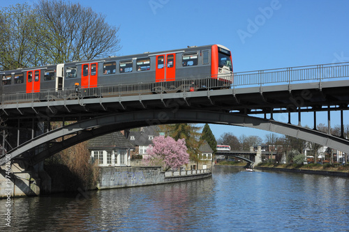 U-Bahn city train crosses the Alster river on the bridge in Hamburg.