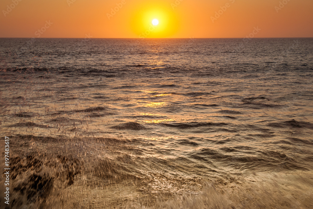 Wave crashing at sunset