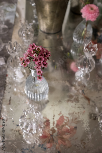 Table decorated with pink rosemary flower in glass crystal vase