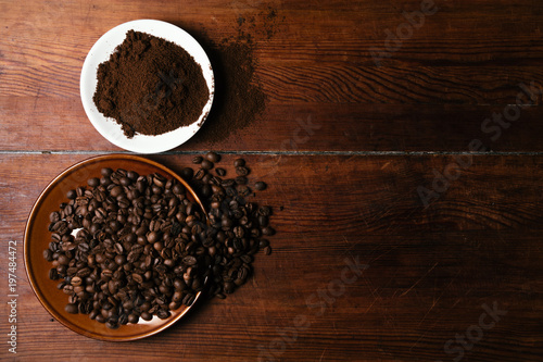 Coffee beans and coffee ground on dark wooden background
