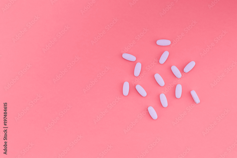 White vaginal pills on a bright pastel pink background and a place for the text. Flat lay