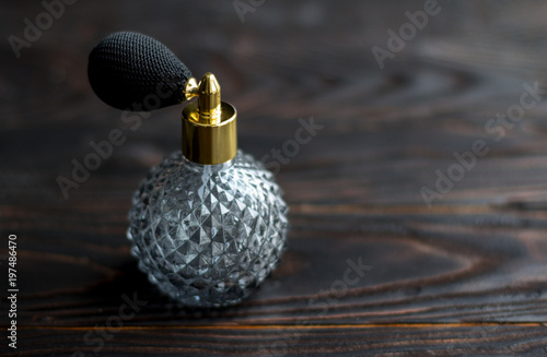 Perfume bottle on dark wooden background © Darya Lavinskaya