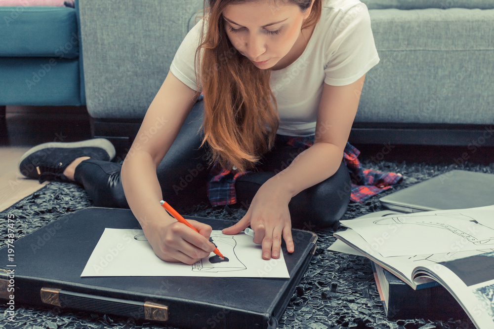 Female designer drawing sketches on a piece of paper.