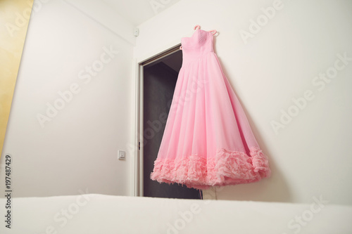 pink dress hanging on doorway