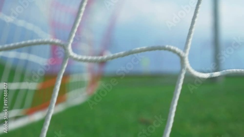 Goal ! Football game - soccer player scoring. Beautiful dolly shot (slow motion) of the ball entering in the cage. Bright sunny day.