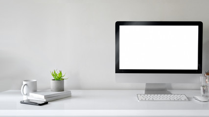Workspace with computer with blank white screen
