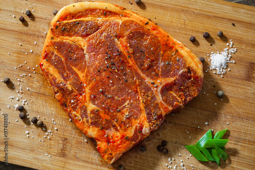 Obraz na plátně Raw marinated meat Steak for bbq, pork chop on a Wooden Chopping Board