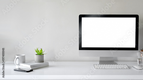 Workspace with computer with blank white screen