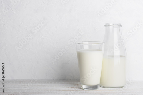 Bottle and glass of milk on white wooden table still life with copy space