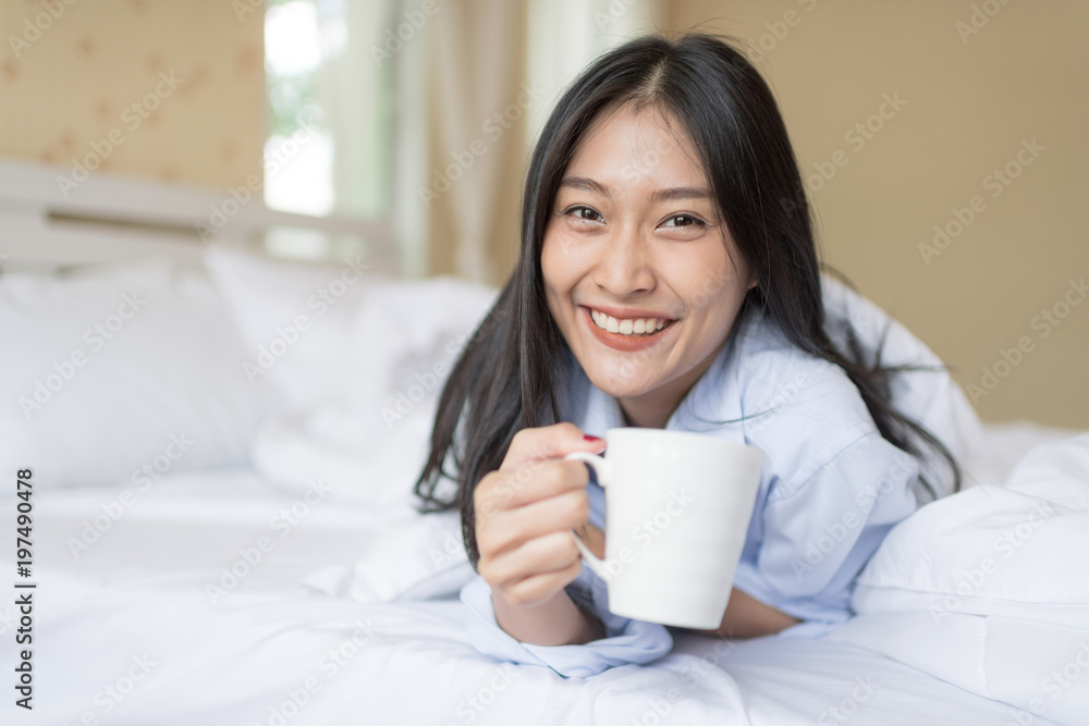 Happy Woman laying and have a breakfast coffee on bed after wake up. Happy Woman laying and have a breakfast coffee on bed after wake up.