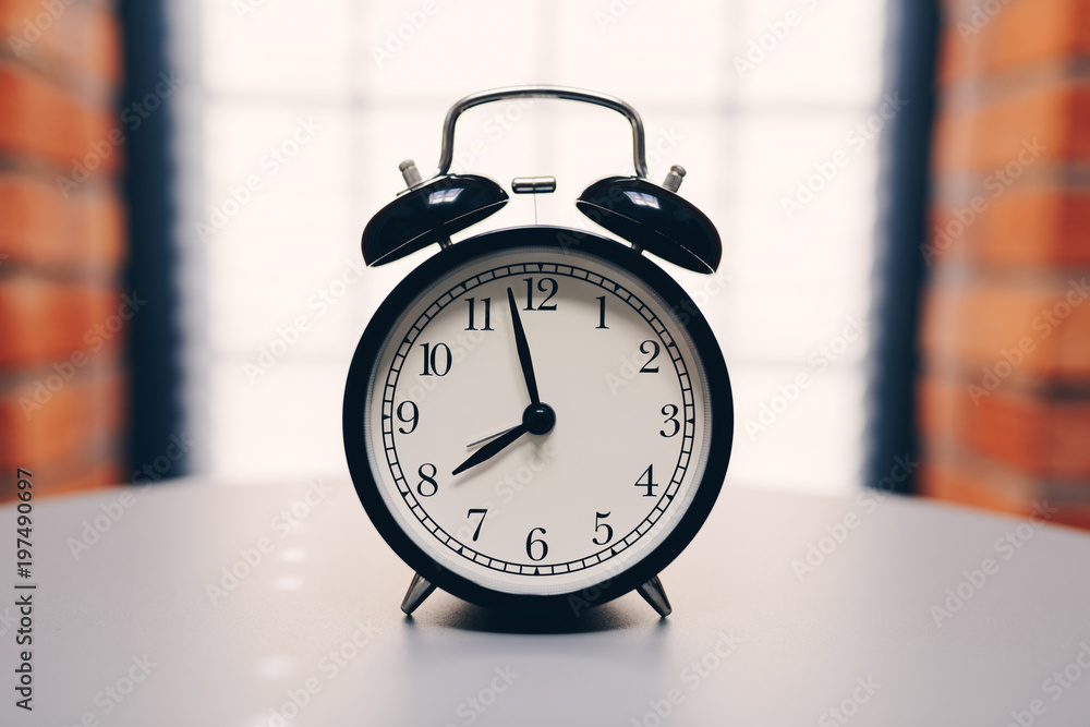 Retro alarm clock on table on white background Retro alarm clock on table on white background