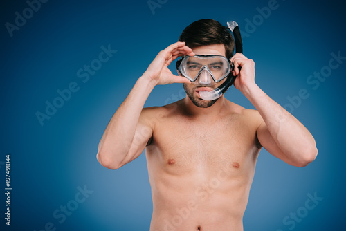 handsome shirtless young man in snorkel and scuba mask looking at camera on blue © LIGHTFIELD STUDIOS
