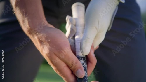 Pro golfer, perfect grip. Pro golfer holding his club, adjusting the position of his fingers