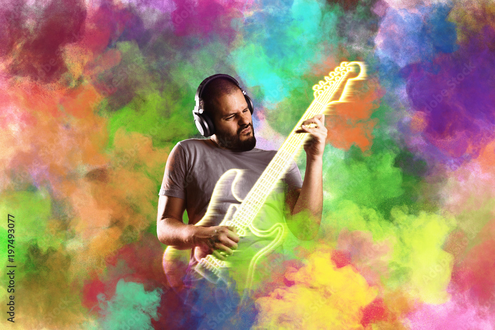 Man with headphones plays virtual electric guitar in holi color cloud